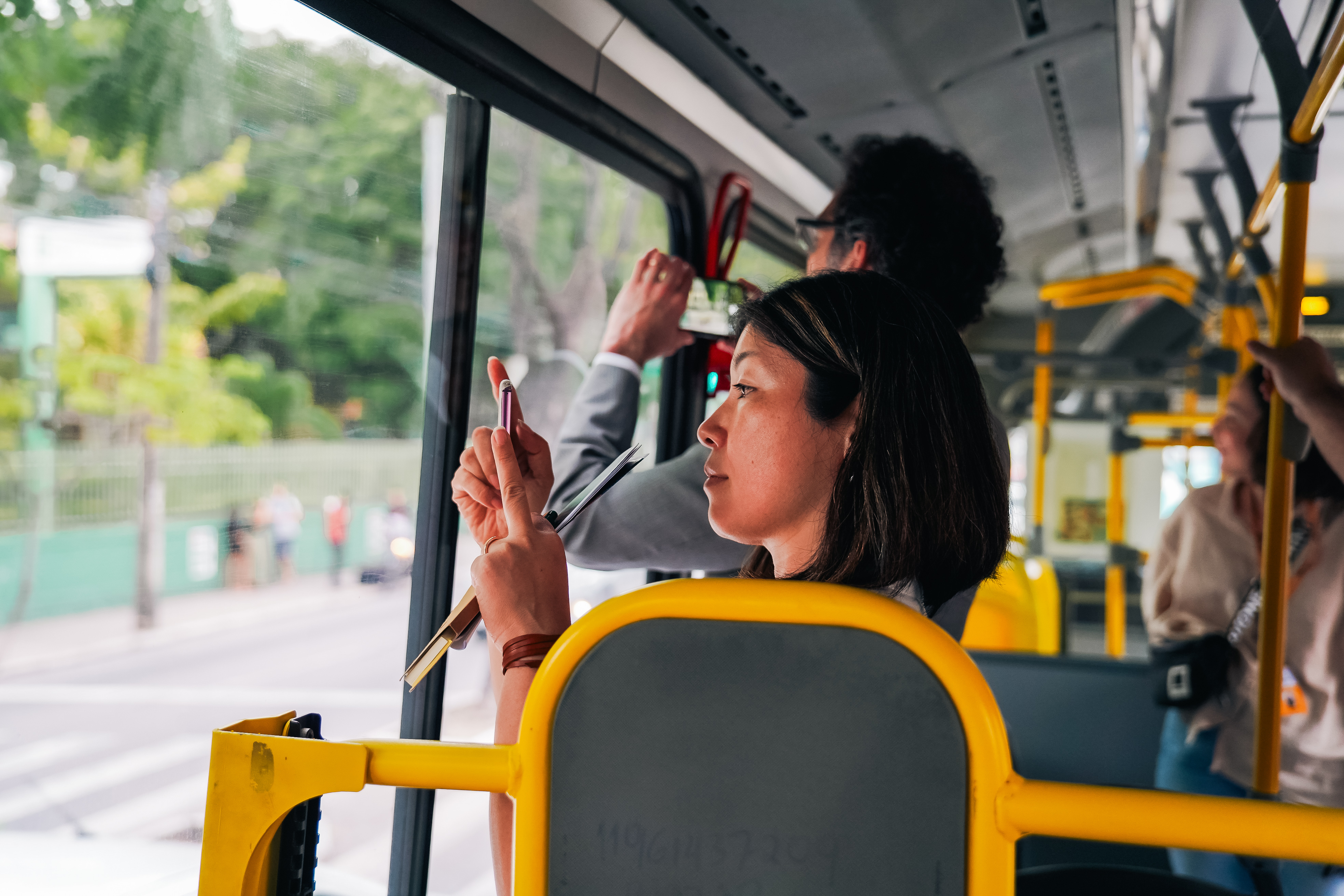mulher tirando foto de celular dentro de um ônibus
